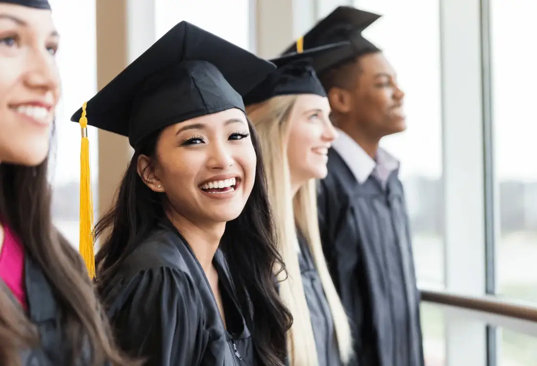 A girl who is in cap and gown at her graduation, as she prepares to go to her party which is catered for.