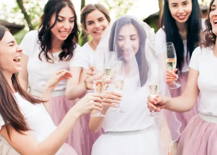 : A bride to be and her bridal party at her hen do as they celebrate with drinks and catering.