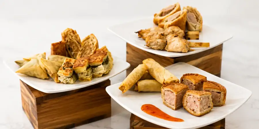 Platter of sausage rolls, pork pies, samosas and falafel