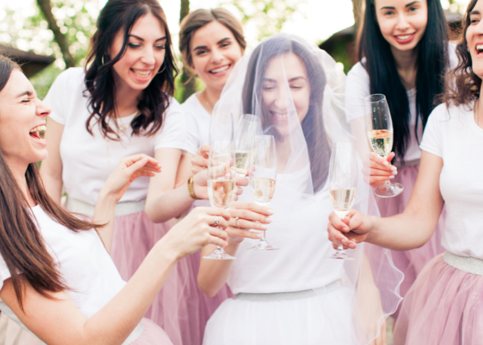 : A bride to be and her bridal party at her hen do as they celebrate with drinks and catering. 